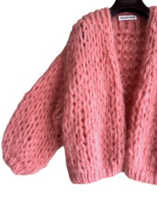 Grof gebreid perzik roze alpaca vest in kort model van Maison Osé. Koraal roze vest met oversized fit, hand gebreid met grote lussen voor een chunky look.