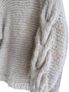 Oversized beige mohair sweater in lang model met kabels op de mouwen.