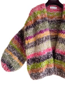 Dit oversized damesvest in eco-friendly geproduceerde mohair is met de hand gebreid. Het vest is gebreid met mohair van Fonty (75% mohair, 20% wol en 5% polyamide) en van Lang Yarns (mohair 93% en polyamide 3%). In het vest is een oudroze draad als basis gebruikt en gemengd met andere kleuren zoals aubergine, bruin, roze, groen, cyclaam, geel, pistache en oranje.