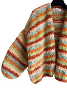 De strepen in het vest zijn in de kleuren pistache, abrikoos, oranje, roest en zeegroen. De kleuren van het breiwerk zorgen voor een mooi effect in het gebreide vest. De prachtige kleurencombinatie met groen en oranje kan het hele jaar door gecombineerd worden in je garderobe