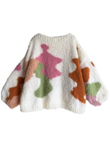 In de sweater zijn organische vormen ingebreid met intarsia techniek. De Kyle sweater is gemaakt in offwhite met beige, oranje, roze en groen.