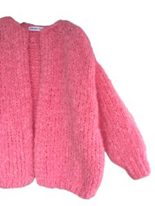 Dit oversized damesvest Hannah in zachte perzik roze mohair is met de hand gebreid.